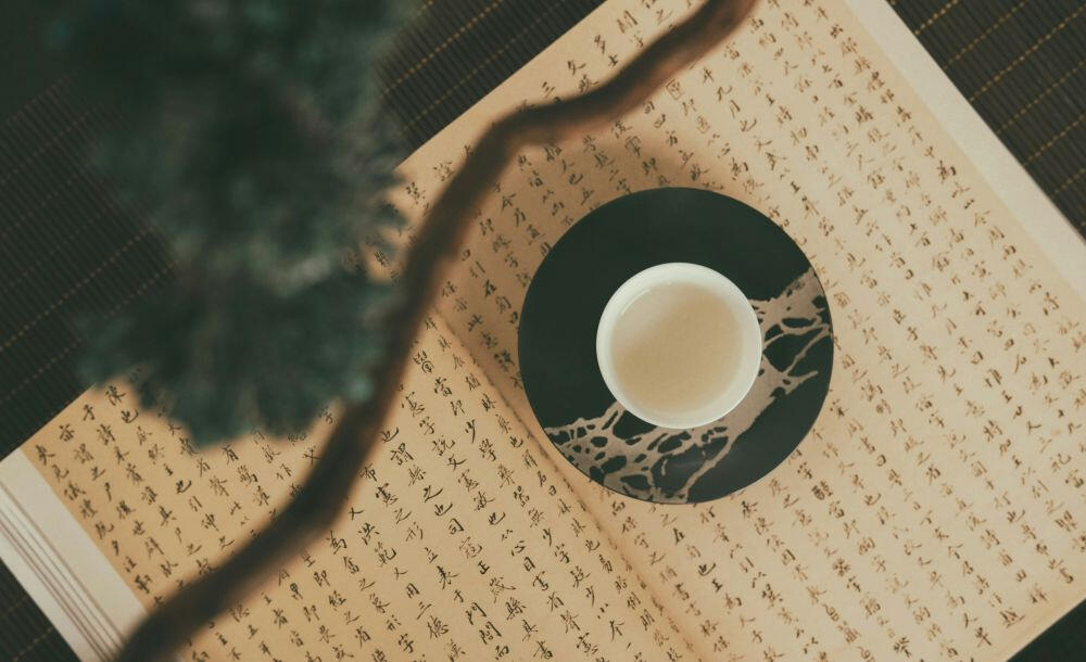Traditional Tea and Chinese Medicine Cup of Chinese tea with Chinese writing in the background